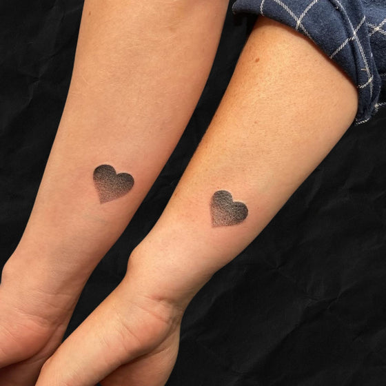Partner Tattoo mit jeweils einem Herz auf dem Unterarm von Mann und Frau im Dotwork Stil vom Atelier Hannibal Tattoo Studio in Hürth