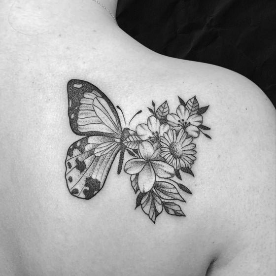 Schmetterling tattoo mit floralen elementen auf schulterblatt, gestochen im Atelier Hannibal Tattoo Studio in Euskirchen